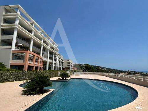 une piscine devant un immeuble dans l'établissement T3 avec grande terrasse et vue panoramique sur la mer, à Sète