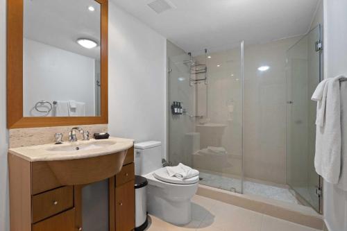 a bathroom with a shower and a sink and a toilet at Beachfront - Eagle Beach - Sapphire 2BR condo E322 in Palm-Eagle Beach