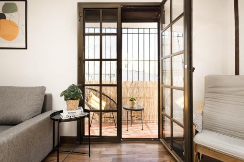 a living room with a couch and a glass door at Nordik Rooms Village - Torremolinos "Undredal" in Torremolinos