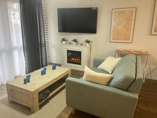 a living room with a couch and a fire place at Cosy Urban Retreat in the Heart in Toowoomba