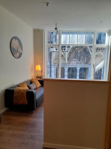 a living room with a couch and a large window at La porte in Huy