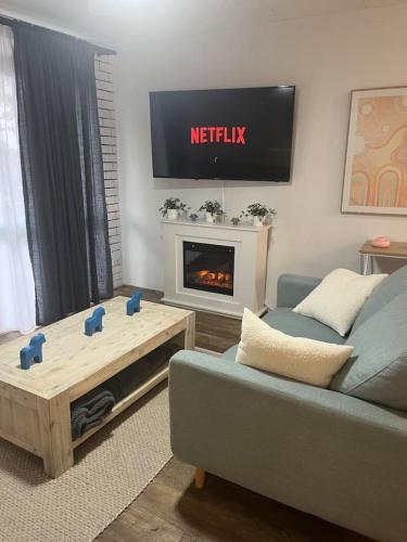 a living room with a couch and a fire place at Cosy Urban Retreat in the Heart in Toowoomba