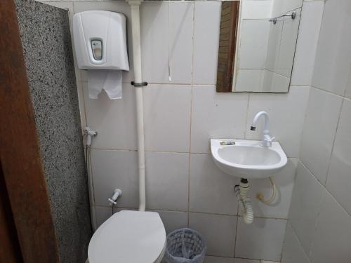 a small bathroom with a toilet and a sink at Pousada Tropical (Adults Only) in Marituba
