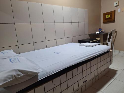 a hospital room with a bed and a table at Pousada Tropical (Adults Only) in Marituba