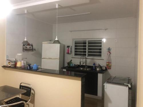 a kitchen with a sink and a refrigerator at Recanto do Peró in Cabo Frio