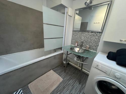 une salle de bain avec une machine à laver et un lavabo dans l'établissement T2 4 couchage très bon emplacement, à Bordeaux