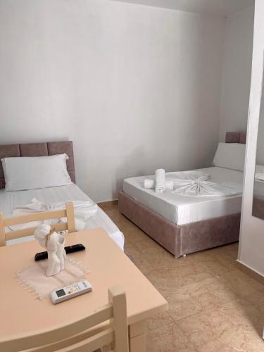 a room with two beds and a table and a table sidx sidx sidx at Kristeo`s Apartaments in Vlorë