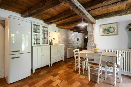 a kitchen with a table and a white refrigerator at Villa Mulino Old Mill in Črnica