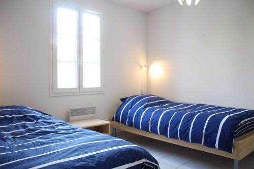 une chambre avec deux lits et une fenêtre dans l'établissement Mais 2 pièces mezza CHATELAILLON PLAGE - CL080-064, à Châtelaillon-Plage
