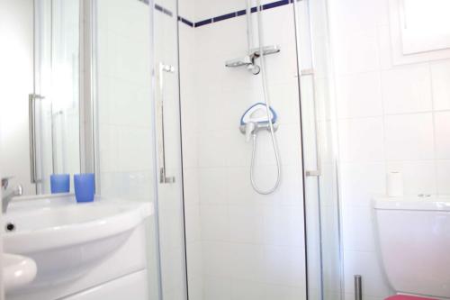 une salle de bain blanche avec une douche et un lavabo dans l'établissement Mais 2 pièces mezza CHATELAILLON PLAGE - CL080-064, à Châtelaillon-Plage