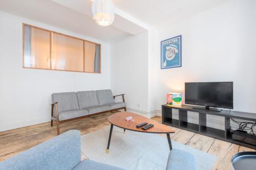 un salon avec un canapé et une télévision dans l'établissement Lille Hypercentre appartement 2 chambres, à Lille