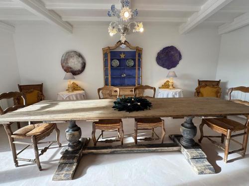 une salle à manger avec une grande table et des chaises en bois dans l'établissement La Batisse de Reve, à Saint-Martin-dʼArdèche