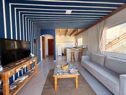 een woonkamer met een blauw-wit gestreept plafond bij Suíte Atenas com hidro aquecida - Arraial do Cabo in Arraial do Cabo