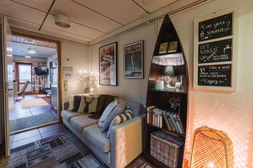 a living room with a couch and a shelf with books at Lodge 67°N Lapland in Äkäslompolo