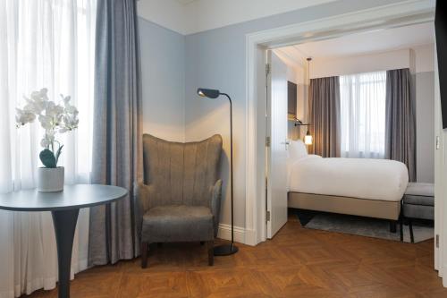a hotel room with a bed and a table and a chair at The Queens Hotel in Leeds