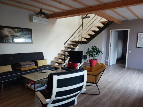 a living room with a staircase and chairs at Gîte de Rosvern in Commana