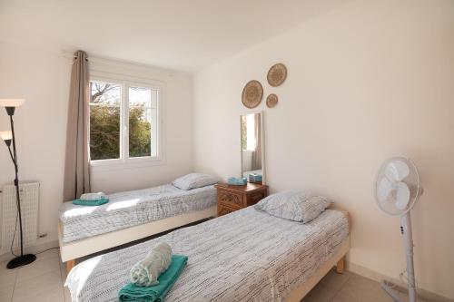 une chambre avec deux lits et une fenêtre dans l'établissement Cosy appartement proche mer, à Antibes