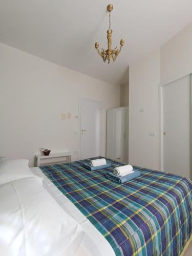 a white room with a bed with a plaid blanket at Agriturismo Terramia in Meggiano