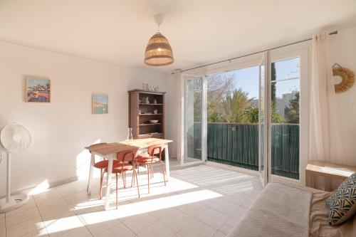 un salon avec une table et des chaises et un balcon dans l'établissement Cosy appartement proche mer, à Antibes
