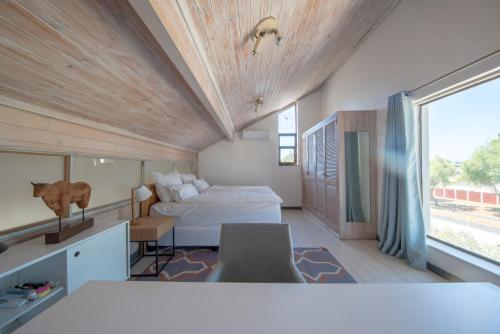 a bedroom with a bed and a large window at Cottage Sauvignon in Plumstead