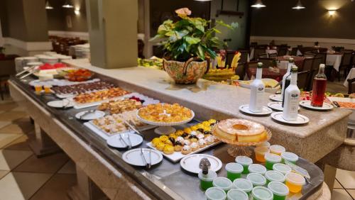 a buffet with many different types of food on a table at Hotel Mantovani in Águas de Lindóia