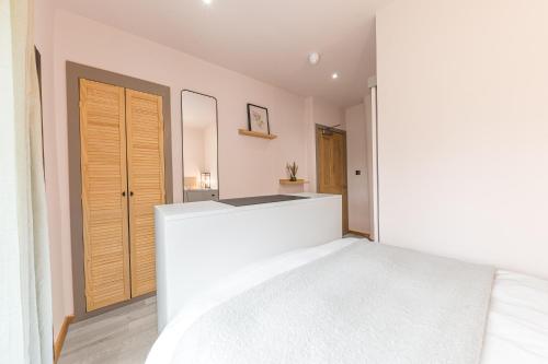 a bedroom with a white bed and a wooden door at Southview Spa Windermere in Windermere
