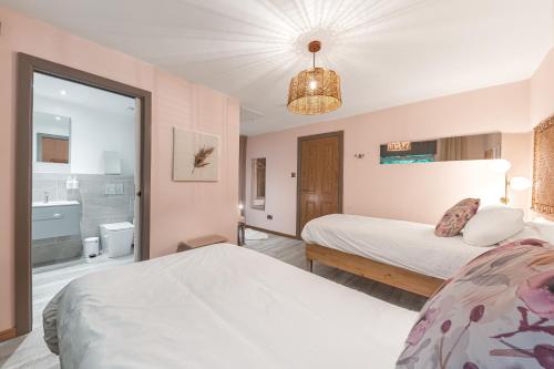 a bedroom with two beds and a bathroom at Southview Spa Windermere in Windermere
