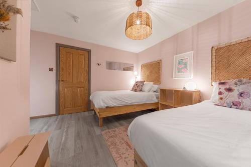 a bedroom with two beds and a wooden door at Southview Spa Windermere in Windermere