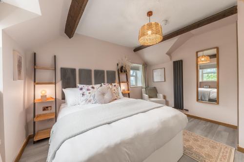 a bedroom with a large white bed and a chair at Southview Spa Windermere in Windermere