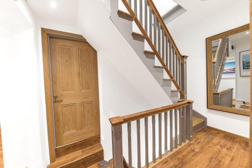a staircase with a wooden door and a mirror at Southview Spa Windermere in Windermere