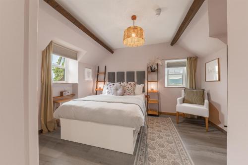 a bedroom with a white bed and a chair at Southview Spa Windermere in Windermere