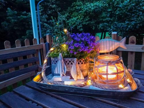 a table with a candle and flowers and a fish tank at Ferienwohnung am Wald in Todenhagen