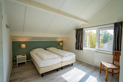 a bedroom with a bed and a window at Vakantiehuis Hoogelandt 134 en 134a in De Koog