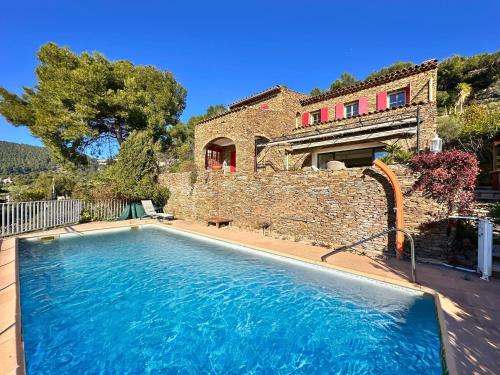 une grande piscine devant une maison dans l'établissement Villa Serena climatisée pour 8 personnes avec piscine privée et vue mer à Carqueiranne, à Carqueiranne