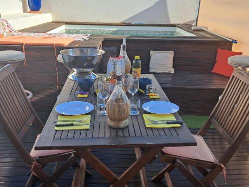 - une table en bois avec des verres à vin sur la terrasse dans l'établissement Sous le soleil, à Bandol