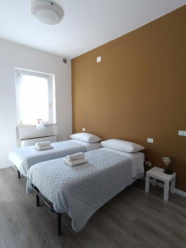 two twin beds in a room with a wall at Agriturismo Terramia in Meggiano