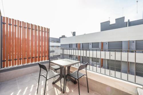 Elegant Studio with Private Terrace by RentitUP في سان سيباستيان دي لوس رييس: شرفة مع طاولة وكراسي في مبنى