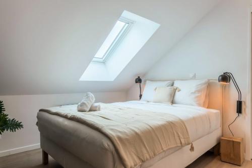 - une chambre avec un lit et une lucarne dans l'établissement Studio sous les combles côté cour, parking gratuit, à Villeneuve d'Ascq