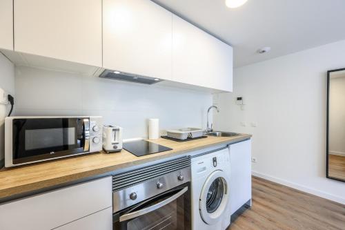 Elegant Studio with Private Terrace by RentitUP في سان سيباستيان دي لوس رييس: مطبخ مع ميكروويف وغسالة ومجفف