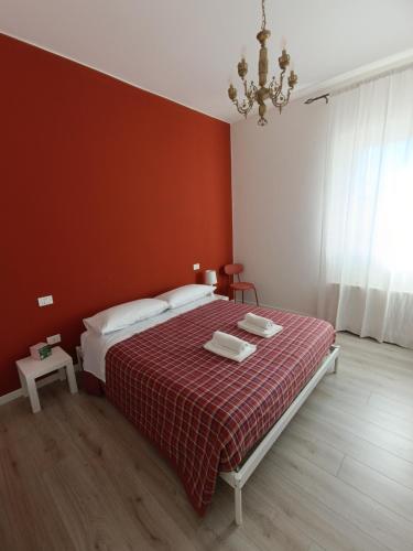 a bedroom with a bed with a red wall at Agriturismo Terramia in Meggiano