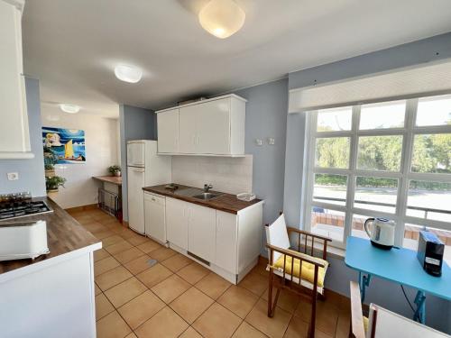 a kitchen with white cabinets and a blue counter top at Vilamoura Sunny Garden With Pool by Homing in Vilamoura