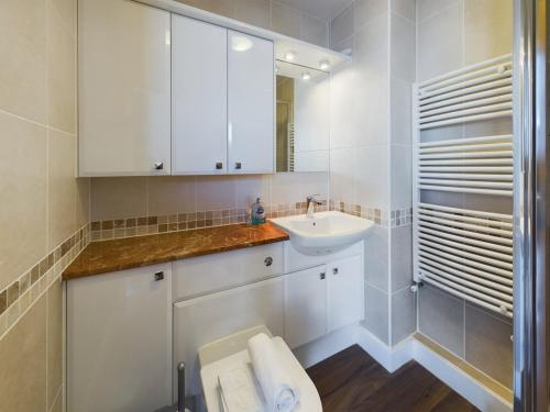 Un baño blanco con lavabo e inodoro. en Granville Lookout - 2 bed Apt, en Ilfracombe