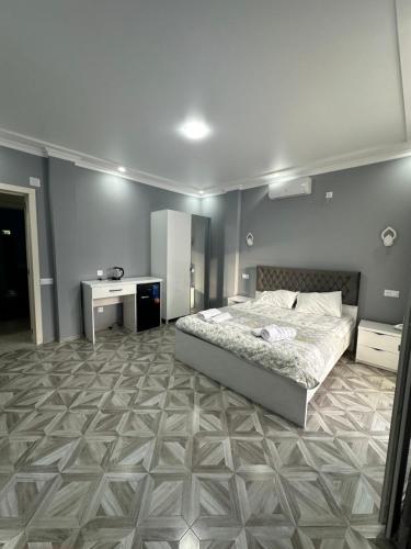 a bedroom with a bed and a desk in it at Marina kvariati in Kvariati