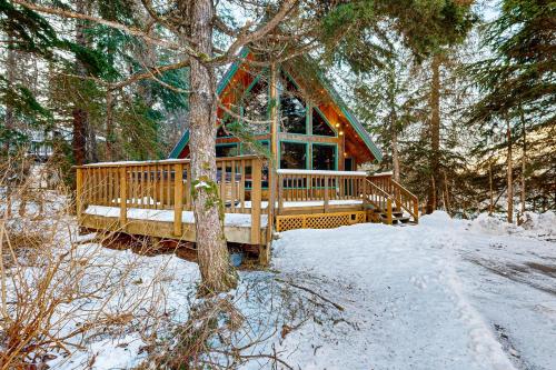 eine Hütte im Wald im Schnee in der Unterkunft Kelly's Chalet in Girdwood