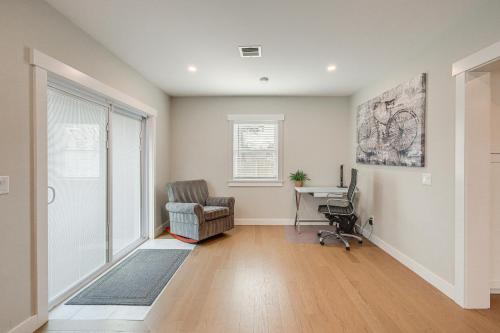 an empty living room with a chair and a desk at Modern Cape Cod Home with Patio 2 Mi to Beaches! in Hyannis