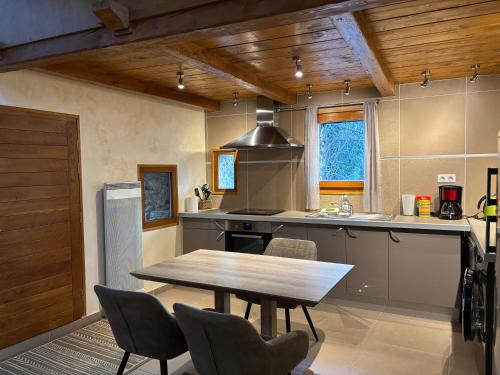 - une cuisine avec une table en bois et un plafond en bois dans l'établissement La Fenière, à Roubion