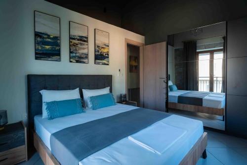 a bedroom with a large bed with blue pillows at Modern Loft at Kalogria Beach in Stoupa