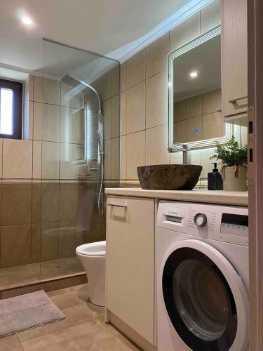 a bathroom with a washing machine and a sink at Modern Loft at Kalogria Beach in Stoupa