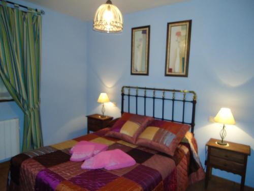 a bedroom with a bed with pink pillows on it at La Casa Madrona-Completa in Villacastín