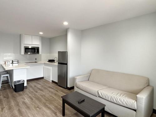 a living room with a couch and a kitchen at Studio 6 Sulphur LA in Sulphur
